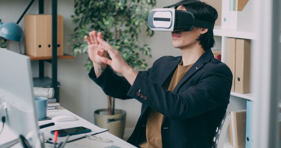 A man in an office environment using a virtual reality headset, engaging with VR content